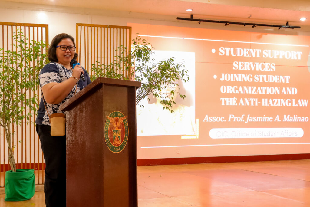 Assoc. Prof. Jasmine A. Malinao speaks about student services and the Anti-Hazing Law at a University of the Philippines podium.